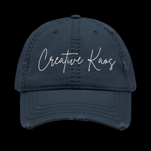 Navy blue cap with 'Creative Kaos' text on a black background